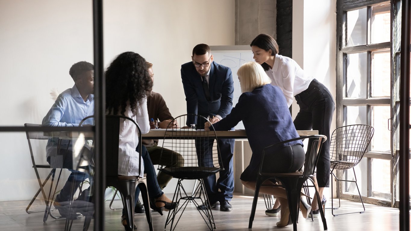 Five colleagues collaborating around a table during a leadership session